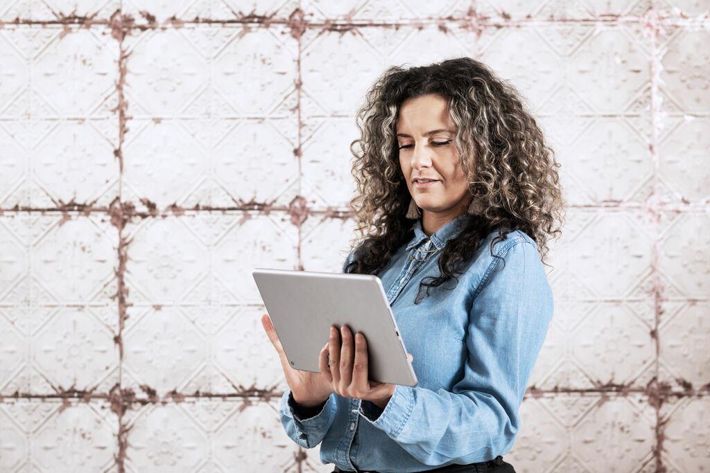 Vrouw staat op een tablet te kijken