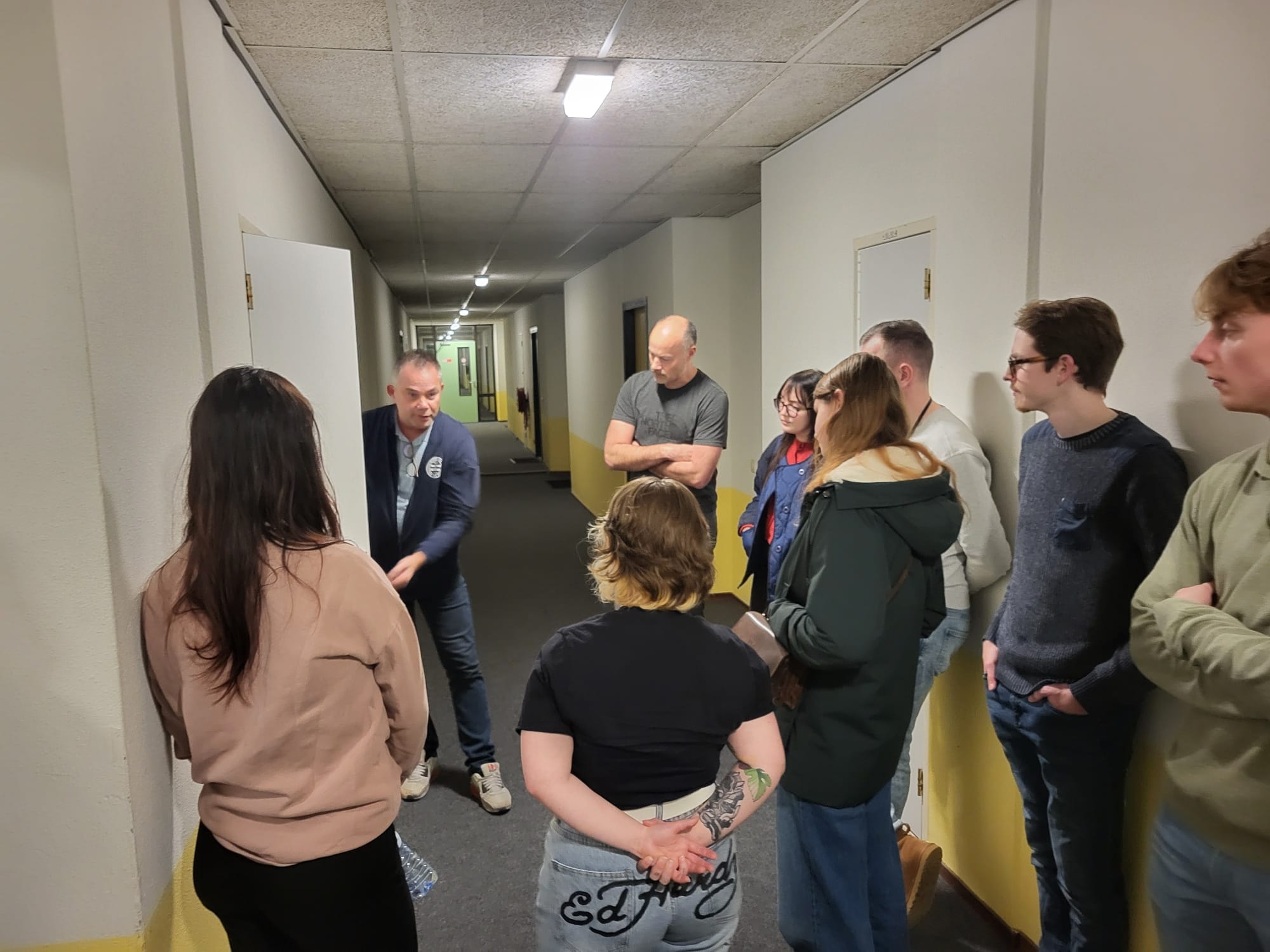 Studenten krijgen uitleg van een huismeester in een woongebouw
